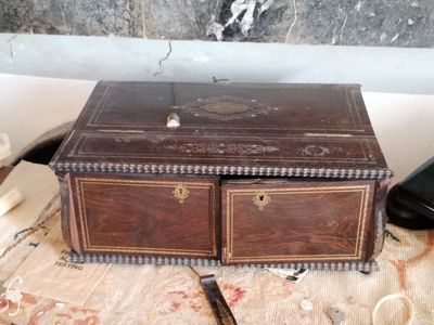 une petite boîte en bois posée sur une table, à côté d'un téléphone