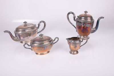 three pieces of silver and copper tea set on a white surface
