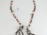 a close up of a necklace on a white surface
