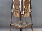 a chair made out of old baseball bats on a wooden stand
