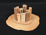 a small model of a castle on a black surface