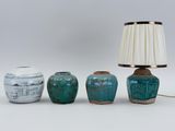three vases and a lamp on a table