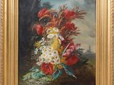 painting of a bouquet of flowers in a gold frame on a wall
