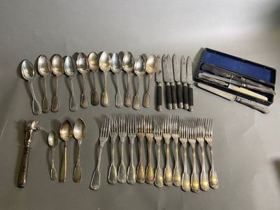 un grand nombre de cuillères et de fourchettes disposées sur la table
