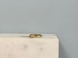 an image of a gold wedding ring on a white marble block