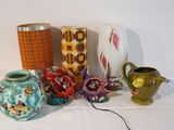 many vases and a lamp on a table