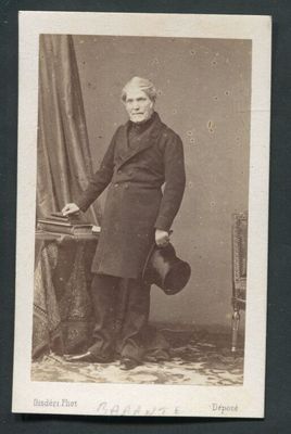 une vieille photo d'un homme en manteau et chapeau