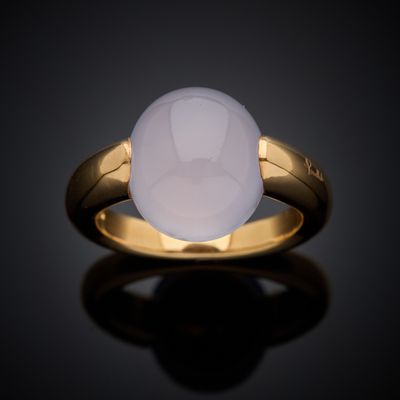 a gold ring with a white jade stone in the center