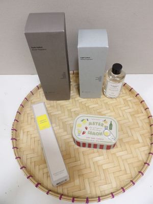 un petit plateau sur lequel se trouvent un flacon de parfum, une boîte de savon et une boîte de lotion