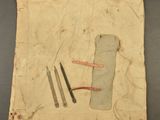an old piece of cloth with tools on it sitting on a table