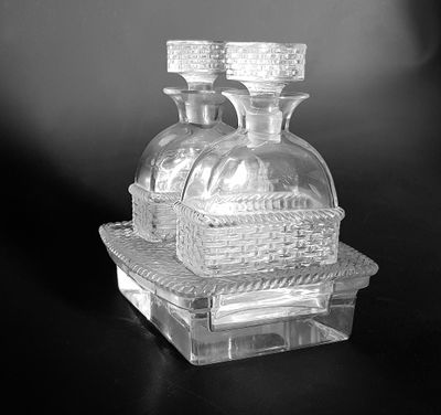 two glass bottles sitting on top of a glass tray