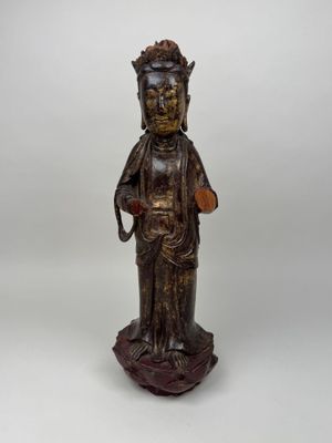 une statue en bois représentant une personne portant un chapeau sur la tête
