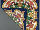 a blue and gold scarf with a design of a horse and wreath