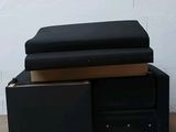 a black couch sitting on top of a pallet next to a white brick wall