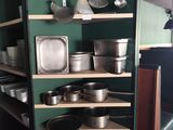 de nombreuses casseroles et poêles sur les étagères de la cuisine