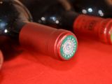 several bottles of red wine are lined up on a red table