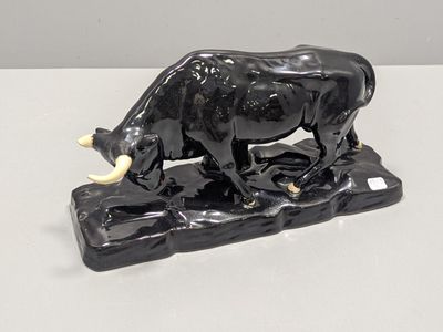 statue d'un taureau posé sur un rocher, sur un fond blanc