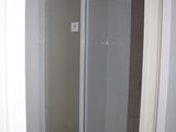 a shower in the corner of a bathroom with a glass door