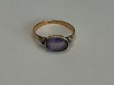 Gros plan sur une bague ornée d'une pierre violette