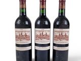 trois bouteilles de vin rouge posées l'une à côté de l'autre sur une surface blanche