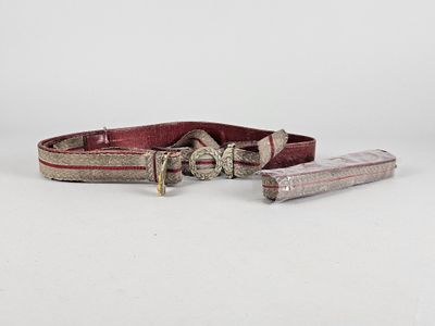 un gros plan d'une ceinture munie d'une boucle métallique sur une surface blanche