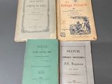 Plusieurs livres sont posés sur une table, avec un ordinateur portable en arrière-plan.