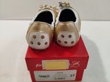 pair of white and gold baby shoes sitting on top of a red box