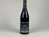 une bouteille de vin posée sur une table blanche