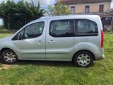 La petite camionnette argentée est garée sur la pelouse devant une maison.