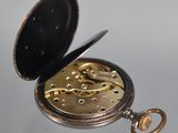 an old pocket watch sitting on top of a glass table