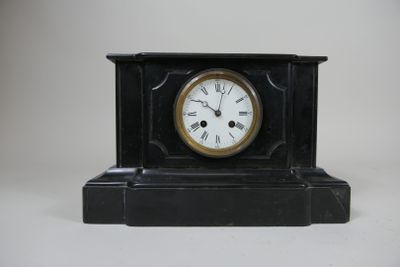 une petite horloge noire avec des chiffres romains