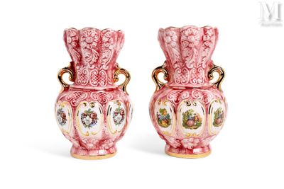 une paire de vases roses et blancs avec des anses dorées sur fond blanc