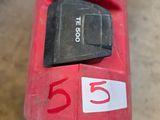 a close up of a red and black cordless drill with a number on it