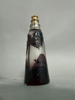 une petite bouteille en verre sur laquelle est représenté un arbre