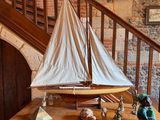 a small sailboat on a wooden table next to a staircase
