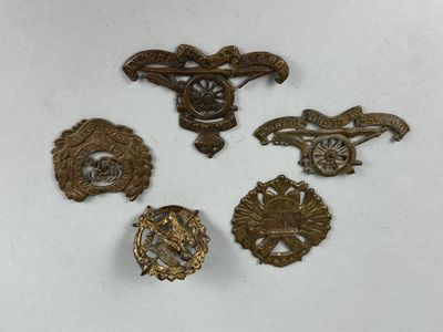 six insignes militaires anciens sont exposés sur un fond blanc