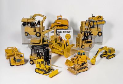 beaucoup de petits engins de chantier en jouets posés sur la table