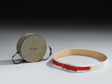 pair of red and white leather bracelets with a round box
