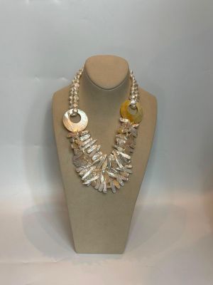 ensemble composé d'un collier et de boucles d'oreilles, présenté sur un mannequin dans une vitrine