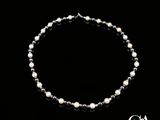 un gros plan d'un collier de perles sur fond noir