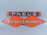 deux panneaux rouges et bleus portant les inscriptions « pneus » et « keeber - colombs »