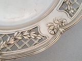 a silver plate with a clock on it sitting on a table