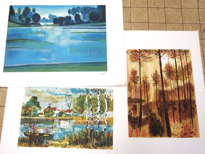 three paintings of trees and a lake are on a table
