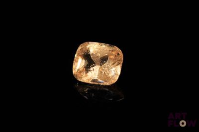 un diamant jaune sur une surface noire dans l'obscurité