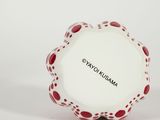 a close up of a white plate with red dots on it