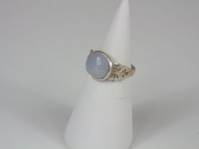 a close up of a ring with a blue stone on a white cone