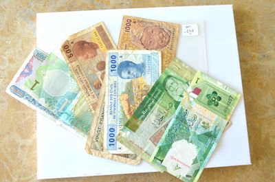 de nombreux billets de banque de différentes valeurs disposés sur une assiette blanche