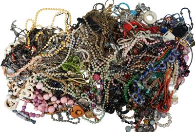 a pile of assorted necklaces and bracelets on a white surface