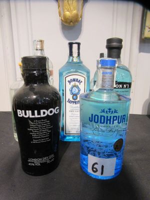 trois bouteilles d'alcool posées les unes à côté des autres sur un comptoir