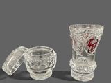 a glass vase and two shot glasses next to each other